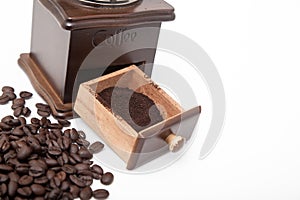 Isolated vintage coffee bean grinder and fresh ground coffee