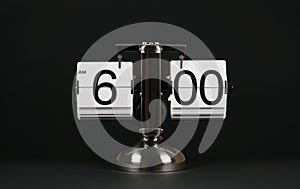 Isolated vintage flip clock on black background at six o`clock