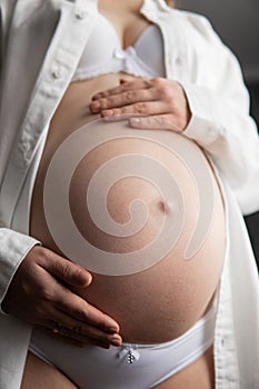 isolated on white background. Pregnant Woman Holding her Belly. Close up of a cute pregnant belly.