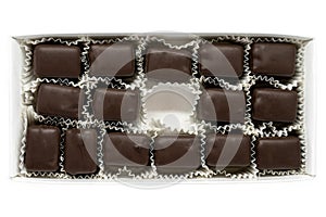 Isolated on a white background, a rectangle box of chocolate truffle pieces with one missing in the middle, signifying eating a