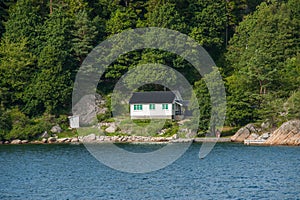 isolated white cabin by the waterÃ¢â¬â¢s edge..