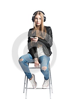 Isolated on white girl is listening music in wired headphones