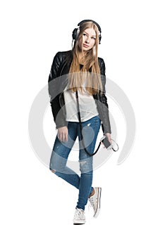 Isolated on white girl is listening music in wired headphones