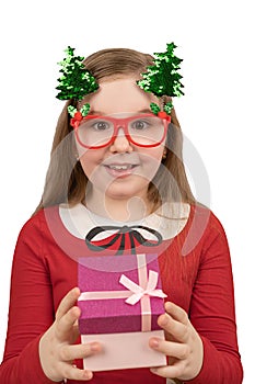 Isolated on white portrait of a cute little girl in funny red glasses and green shiny christmas trees on springs. She wear in red