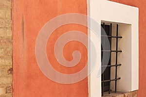 Isolated window with gratings in an orange wall