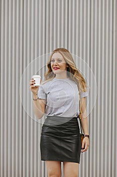 Isolated woman drinking coffee walking on the street