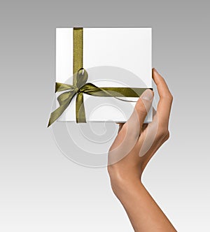 Isolated Woman Hands holding Holiday Present White Box with Green Ribbon on a White Background