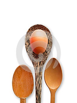 Isolated Wooden Kitchen Utensilsand and healthy food concept, One brown chicken egg on wood spoon with white background-selective