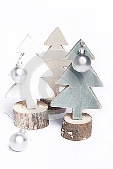 Isolated wooden pastel Christmas tree decorations with ornaments on white background, composition with bright Christmas trees