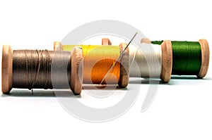 Isolated wooden spools of thread and needle