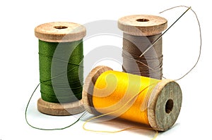 Isolated wooden spools of thread with a needle