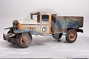 isolateded old tin cargo truck toy from the year 1950 faded profile