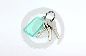 Isolatedâ€‹ theâ€‹ doorâ€‹ keyâ€‹sâ€‹ andâ€‹ greenâ€‹ tagâ€‹ onâ€‹ whiteâ€‹ background.