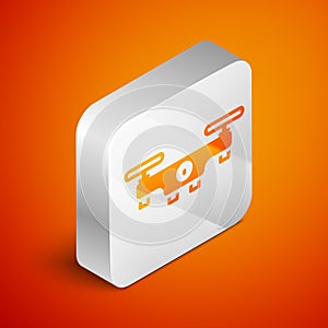 Isometric Drone flying icon isolated on orange background. Quadrocopter with video and photo camera symbol. Silver