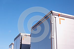 Isotherm cargo semi-trailers on a background of blue sky. The concept of the capacity and volume of a modern semi