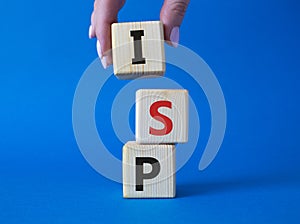 ISP - Internet Service Provider symbol. Concept word ISP on wooden cubes. Businessman hand. Beautiful blue background. Business