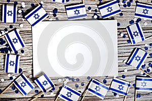 Israel independence day . April 29, 2020. white blue confetti paper with mini Israel flags and white sheet of paper on white