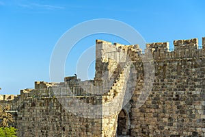 Israel Jerusalem, view of the old city wall, photographed from below with the background of the fence on the wall, against a brigh