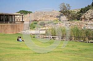 ISRAEL -July 30, - Two teen girl sitting on the grass in the ancient Park of Caesarea, Israel - Caesarea 2015 - Caesarea 2015