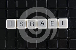 Israel white text word on black cover. Text word crossword. Alphabet letter blocks game texture background.