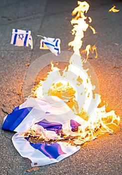 Israeli flag being burned during protest photo