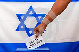 Israeli man putting a ballot in a ballot box on election day.