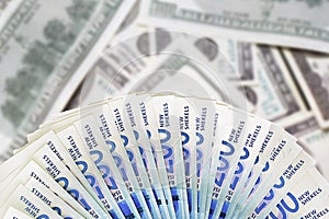 Israeli money notes. Fan shekel banknotes on blur american dollars background