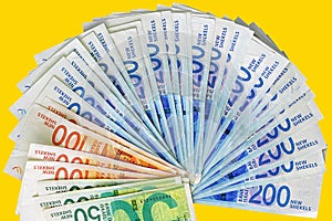 Israeli money notes isolated on yellow background