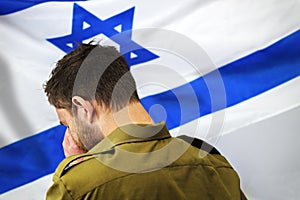 Israeli soldier crying in front of the flag of Israel photo
