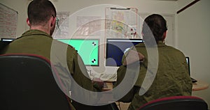 Israeli soldiers in a military command and control room looking at screens