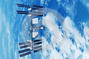 ISS over the planet, against the background of clouds. Elements of this image furnished by NASA