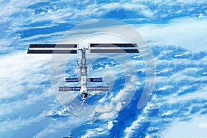 ISS over the planet, against the background of clouds. Elements of this image furnished by NASA