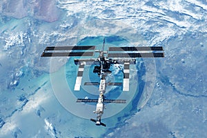 ISS over the planet, against the background of clouds. Elements of this image furnished by NASA