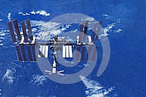 ISS over the planet, against the background of clouds. Elements of this image furnished by NASA