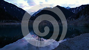 Issyk mountain lake with mirror water at sunset.