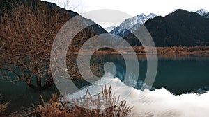 Issyk mountain lake with mirror water at sunset.