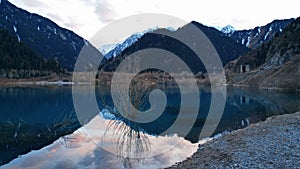 Issyk mountain lake with mirror water at sunset.