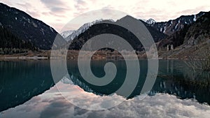 Issyk mountain lake with mirror water at sunset.