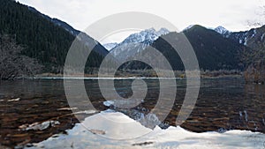 Issyk mountain lake with mirror water at sunset.