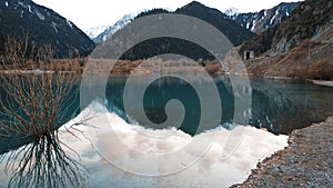 Issyk mountain lake with mirror water at sunset.