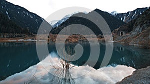 Issyk mountain lake with mirror water at sunset.