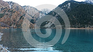 Issyk mountain lake with mirror water at sunset.