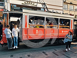 Tourists and local people travelling by historical red tramway | tramvay in Taksim Istiklal Street.