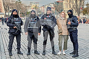 A young woman is photographed with police officers at Sultanahmet Meydani in Istanbul, Turkey.