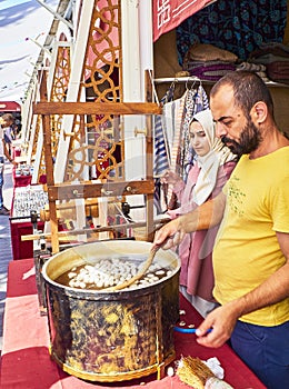 Workers boiling and unwinding silkworm cocoons to make silk thread at an Arab market of Istanbu