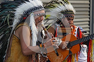Red Indians Native Americans play flute and guitar in feather headdresses