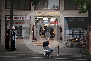 Man using a smartphone mobile phone in front of a store in the center of Istanbul.