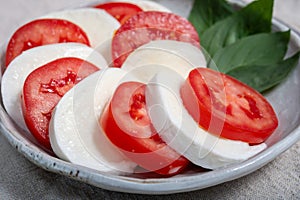 Itaian vegetarian food, fresh caprese salad made with white soft italian mozzarella cheese, red tomato and green basil with olive