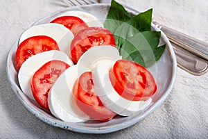 Itaian vegetarian food, fresh caprese salad made with white soft italian mozzarella cheese, red tomato and green basil with olive