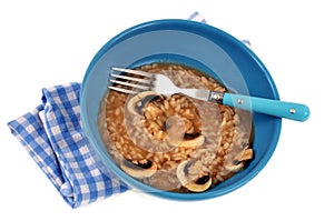Italain meal with rice and mushrooms served in a plate with fork on white background